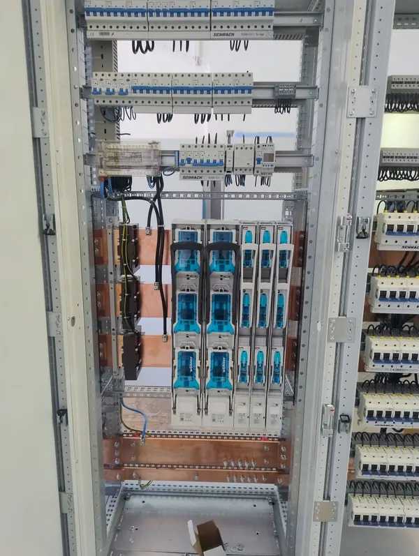 Pole rozłączników NH. Rozłączniki bezpiecznikowe Wöhner, przekładniki prądowe na szynach i aparatura modułowa Schrack.