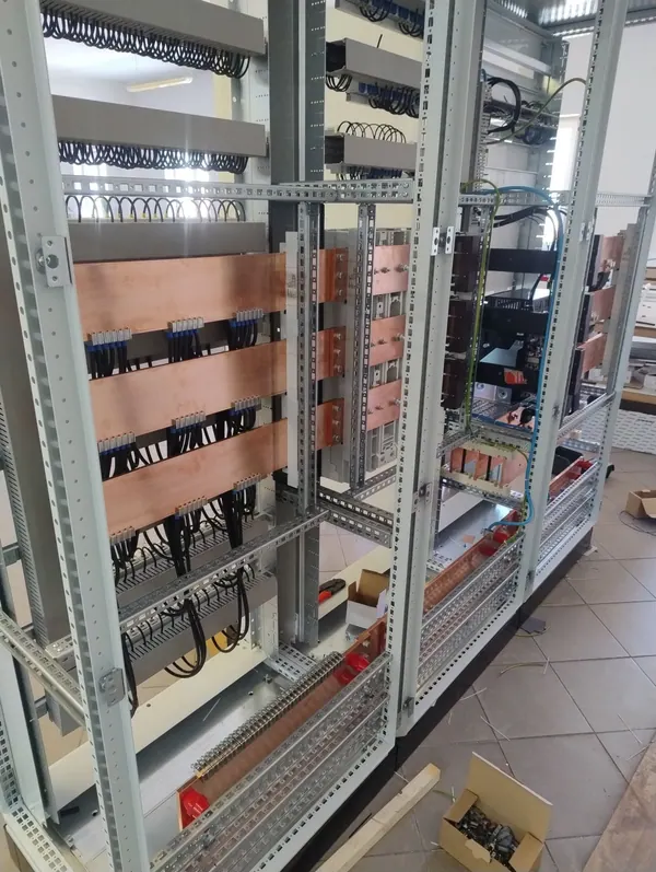 Wielosekcyjna rozdzielnica. Zespół szaf z szynami zbiorczymi, odpływami kablowymi i korytkami prowadzącymi przewody.